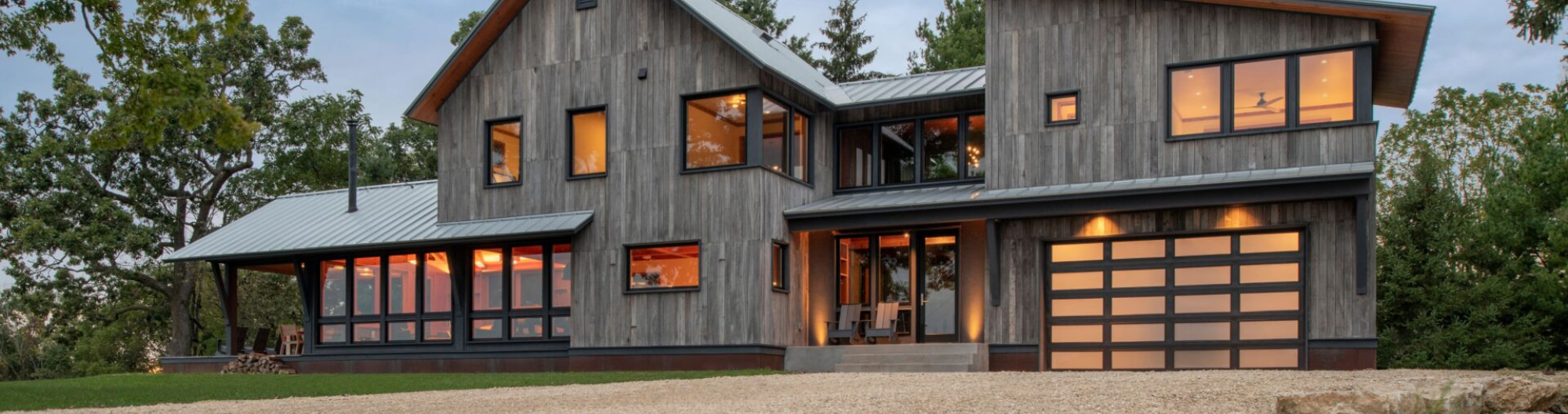 Rustic home with modern garage doors in the woods